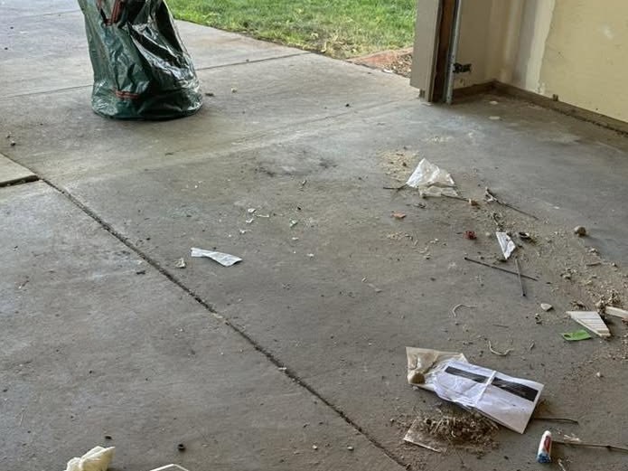 Driveway and garage entry scattered with construction scraps